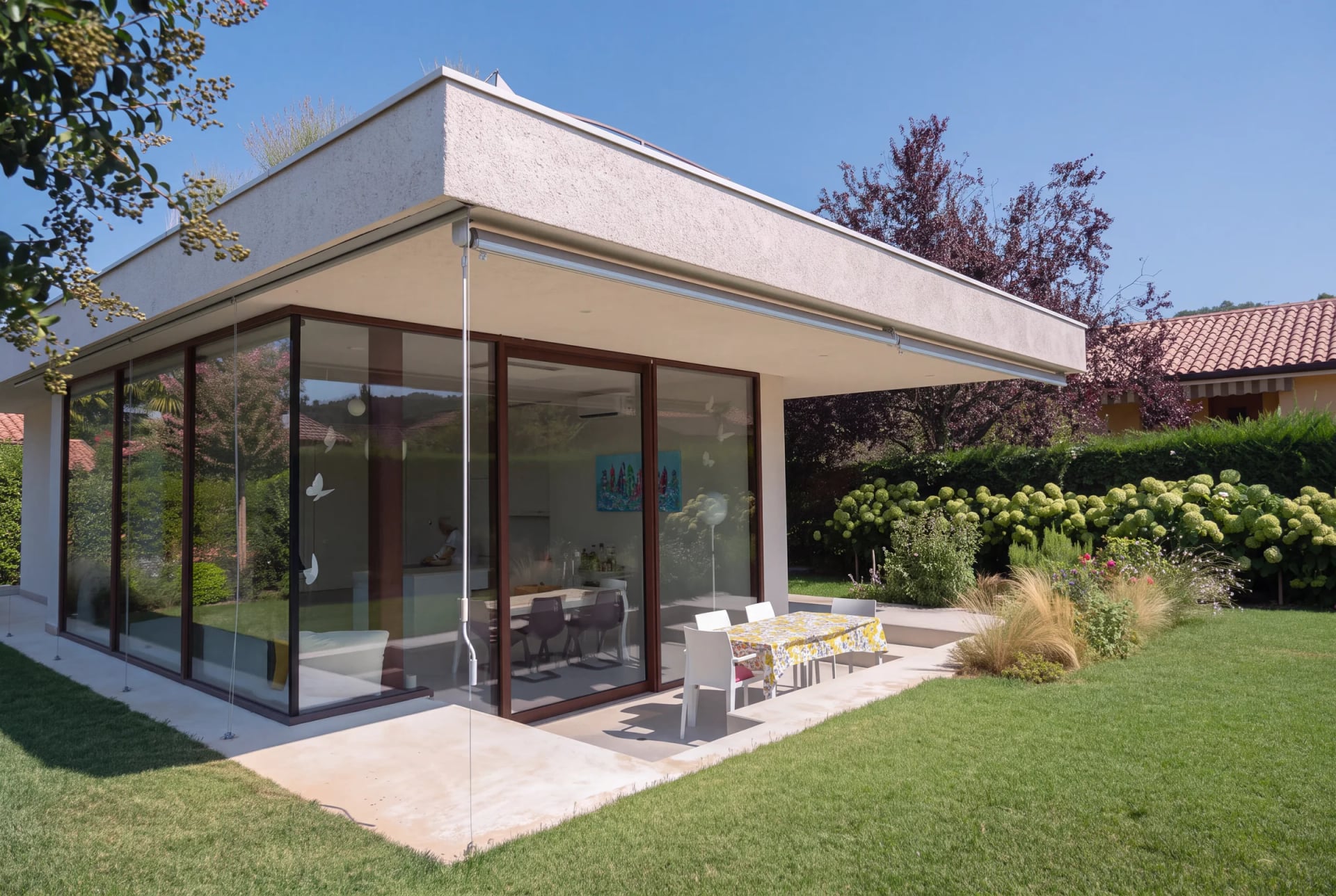 Modern villa with flat roof and floor-to-ceiling glazing, terrace and lawn in front